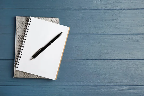 Notebooks en pen op blauwe houten tafel, Top View. Ruimte voor tekst — Stockfoto