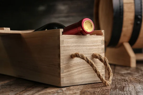 Jaula con botella de vino sobre mesa de madera — Foto de Stock