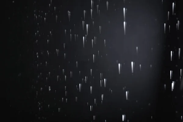 Gotas de agua cayendo sobre fondo negro. Clima lluvioso — Foto de Stock