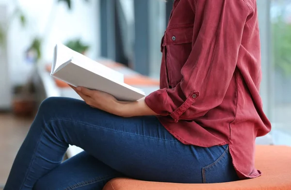 Молода жінка читає книгу в бібліотеці, крупним планом — стокове фото