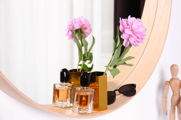 Espelho redondo elegante com óculos de sol, perfume e flor na parede branca dentro de casa. Design de interiores — Fotografia de Stock