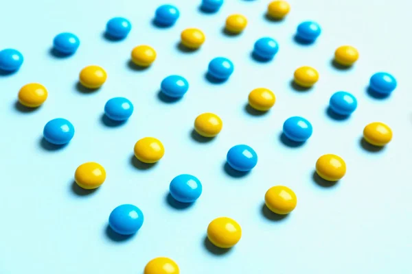 Deliciosos caramelos brillantes sobre fondo azul claro — Foto de Stock