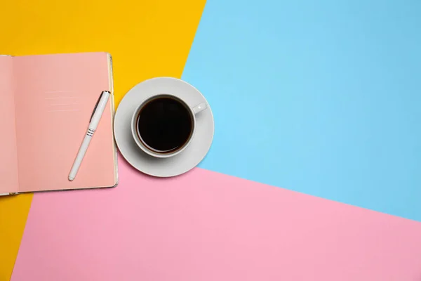 色の背景、トップビューにペンとコーヒーとノートブックのカップ。テキスト用のスペース — ストック写真