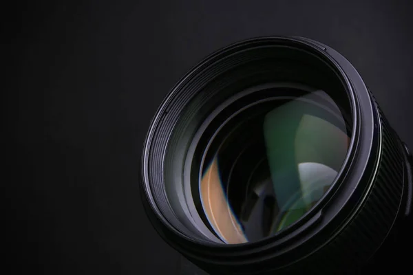 Lente de câmera moderna em fundo preto, close-up. Espaço para texto — Fotografia de Stock