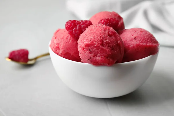 Delicious pink ice cream with raspberries in bowl on grey table — Stock Photo, Image