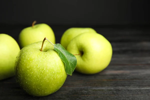 Pommes vertes mûres fraîches sur table en bois noir, espace pour le texte — Photo