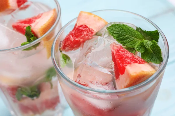 Vasos de pomelo refrescante bebida con cubitos de hielo y menta en la mesa, primer plano —  Fotos de Stock