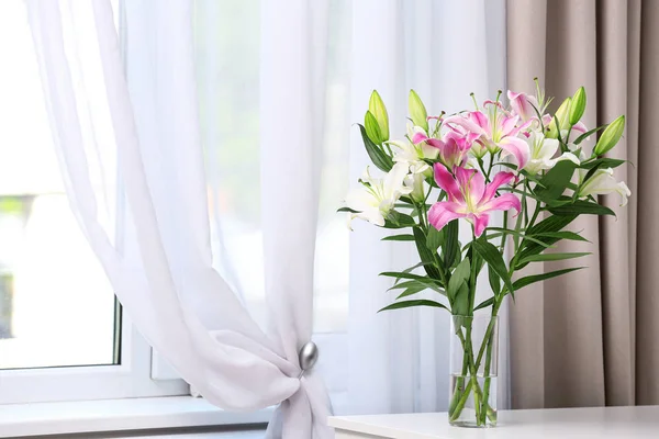 Florero con ramo de hermosos lirios en la mesa blanca en el interior. Espacio para texto — Foto de Stock