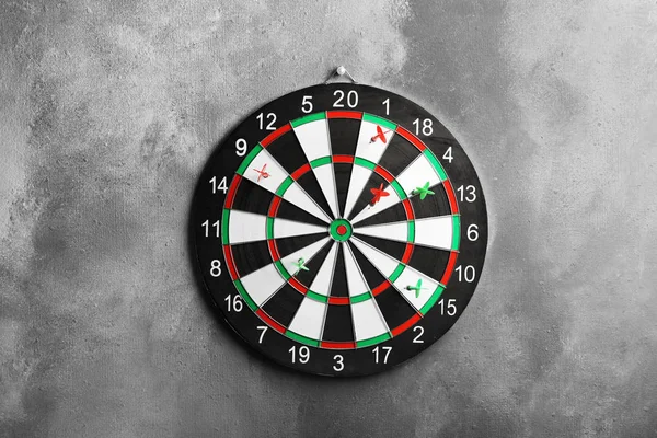 Strzały uderzając Dart Board na szarej ścianie — Zdjęcie stockowe