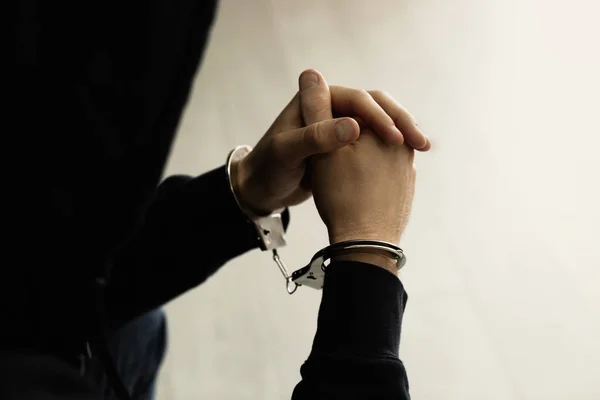 Мужчина, задержанный в наручниках в помещении, вид крупным планом. Уголовное право — стоковое фото
