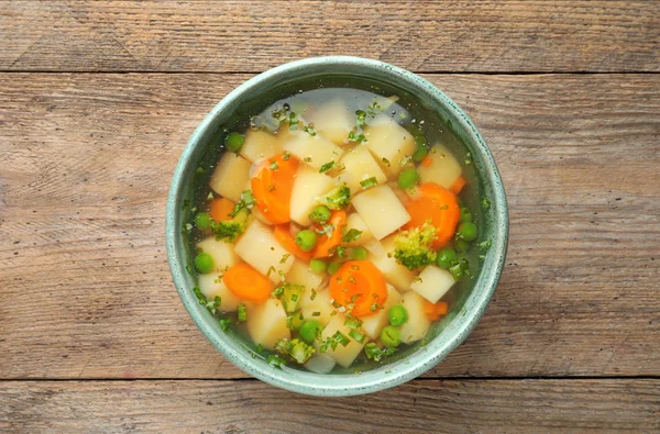 Чаша свежего домашнего овощного супа на деревянном фоне, вид сверху — стоковое фото