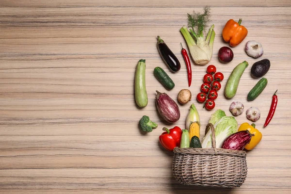 Flache Lagekomposition mit verschiedenen Gemüsesorten und Weidenkorb auf hölzernem Hintergrund. Raum für Text — Stockfoto