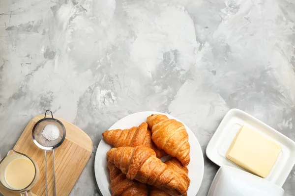 一盘新鲜的羊角面包在灰色的桌子上，平放有文字空间。法国糕点 — 图库照片
