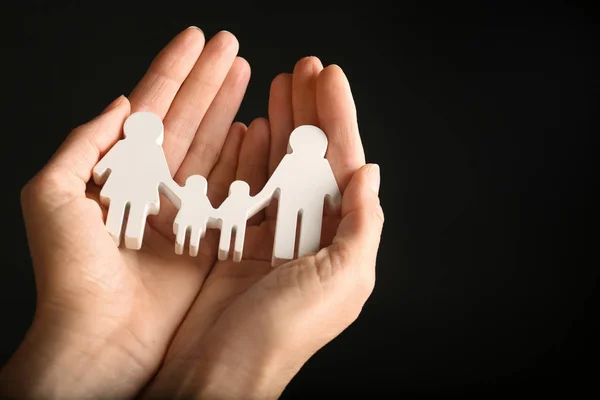 Kvinna som håller siffran familj i händerna på svart bakgrund, närbild. Utrymme för text — Stockfoto