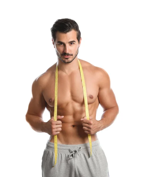 Mladý muž s štíhlým tělem používající měřicí pásku na bílém pozadí — Stock fotografie