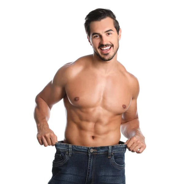 Giovane uomo con corpo sottile in vecchi jeans di grandi dimensioni su sfondo bianco — Foto Stock