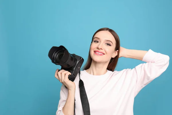 Professionele fotograaf met moderne camera op licht blauwe achtergrond — Stockfoto