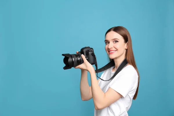 Fotógrafo profissional com câmera moderna em fundo azul claro — Fotografia de Stock