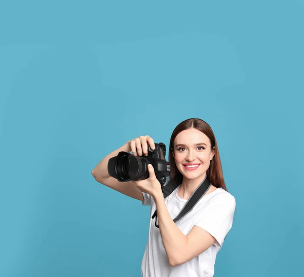 Fotógrafo profissional com câmera moderna em fundo azul claro — Fotografia de Stock