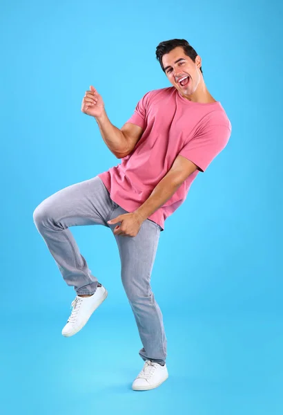 Schöner junger Mann tanzt auf blauem Hintergrund — Stockfoto