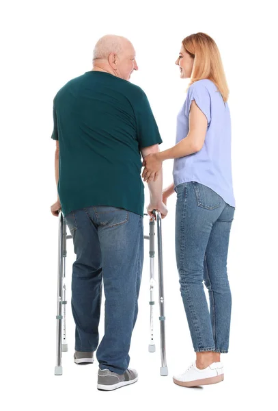 Cuidador ayudando a anciano con marco de caminar sobre fondo blanco — Foto de Stock