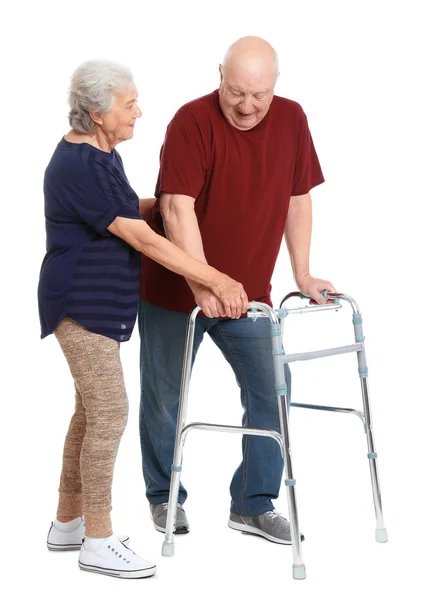 Starsza kobieta pomaga jej mąż z chodzeniem ramki na białym tle — Zdjęcie stockowe