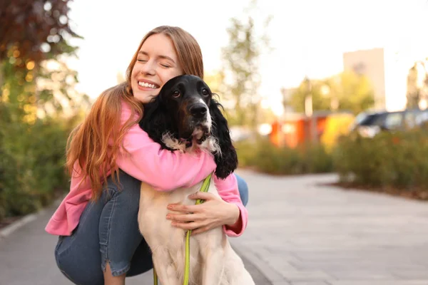 Young woman hugging her English Springer Spaniel dog outdoors. Space for text — Stock Photo, Image