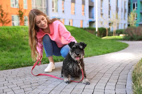 Young woman with Miniature Schnauzer dog outdoors