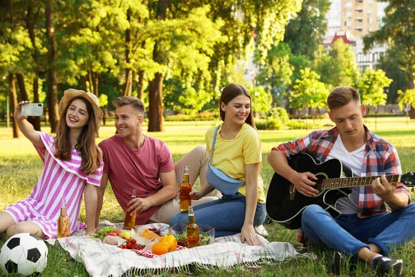 Jóvenes disfrutando de un picnic en el parque el día de verano — Foto de Stock