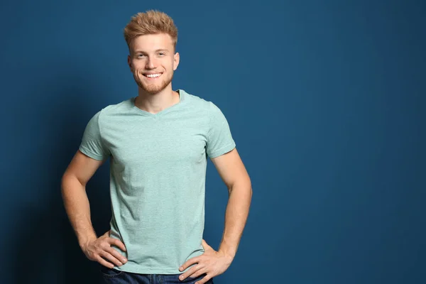 Un joven con una camiseta en blanco sobre fondo azul. Burla para el diseño —  Fotos de Stock