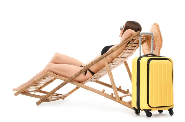 Young woman with suitcase on sun lounger against white background. Beach accessories — Stock Photo, Image