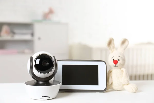 Babyfon mit Kamera und Spielzeug auf dem Tisch im Zimmer. Video-Kindermädchen — Stockfoto