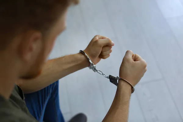 Człowiek zatrzymany w kajdankach w pomieszczeniu, widok zbliżenie. Prawo karne — Zdjęcie stockowe