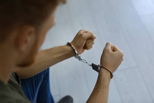 Homem detido algemado dentro de casa, vista de perto. Direito penal — Fotografia de Stock