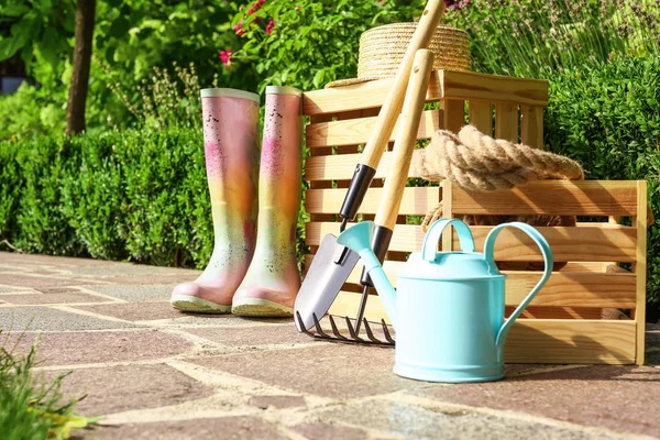 Wooden crates and gardening tools on stone path at backyard — Stock Photo, Image