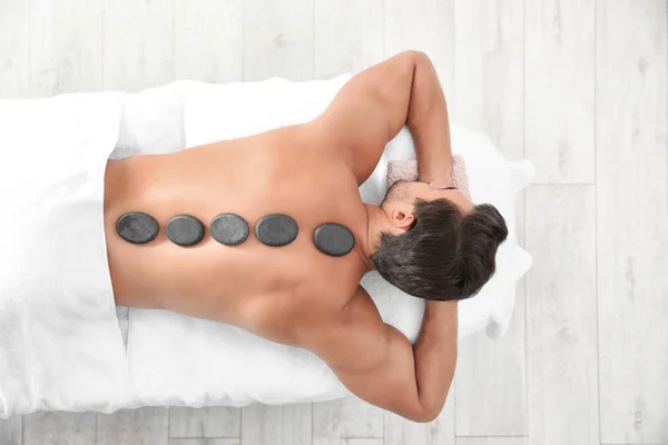 Jonge man ontvangen Hot Stone massage in Spa Salon, Top uitzicht. Ruimte voor tekst — Stockfoto