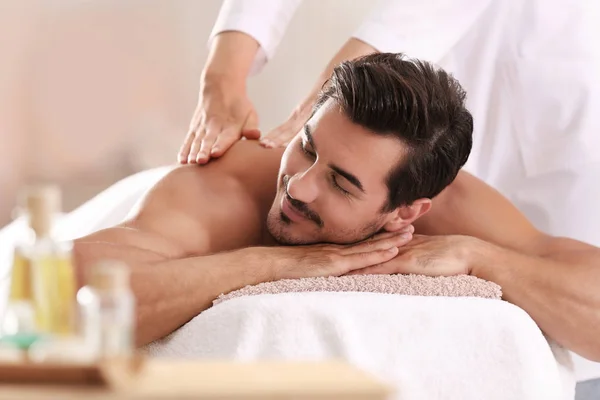 Schöner junger Mann erhält Rückenmassage im Wellness-Salon — Stockfoto