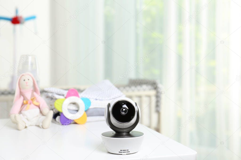 Baby camera and accessories on table in room. Video nanny