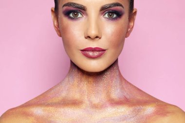 Pembe arka plan üzerinde glitter makyaj ile seksi genç kadın