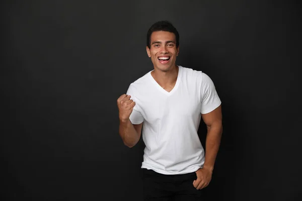 Happy handsome young African-American man on black background — Stock Photo, Image