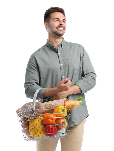 Junger Mann mit Einkaufskorb voller Produkte auf weißem Grund — Stockfoto