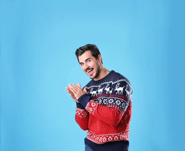 Retrato de jovem feliz em camisola de Natal no fundo azul claro — Fotografia de Stock