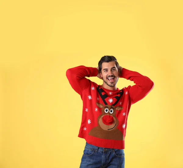 Retrato de jovem feliz em camisola de Natal no fundo amarelo — Fotografia de Stock