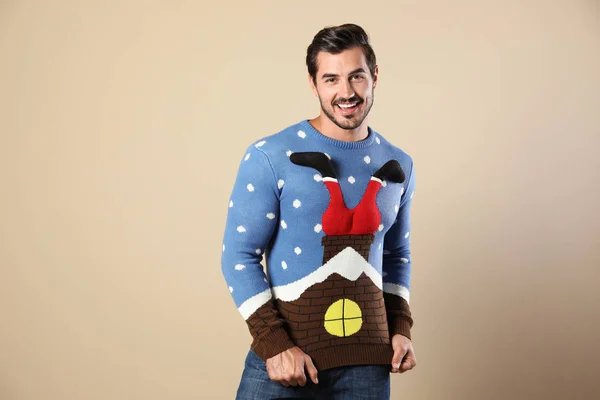 Portrait of happy man in Christmas sweater on beige background — Stock Photo, Image