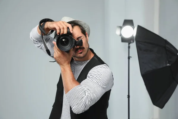 Fotógrafo profissional tirando fotos em estúdio moderno — Fotografia de Stock