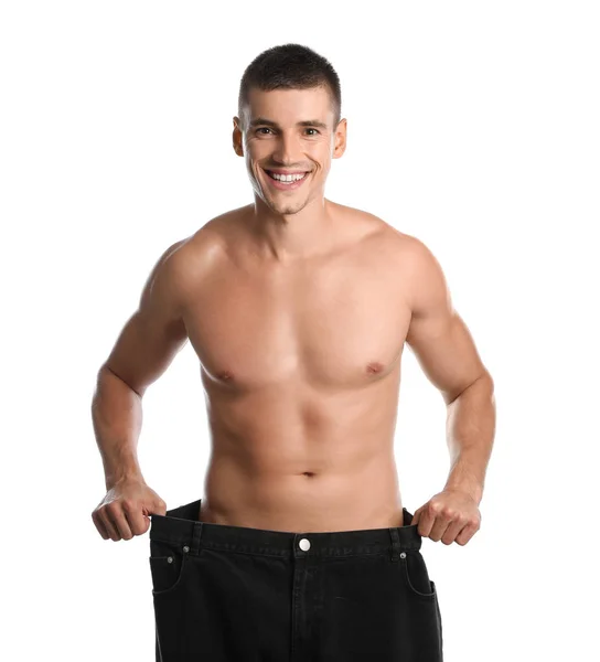 Jonge man met slank lichaam in oude big size jeans op witte achtergrond — Stockfoto