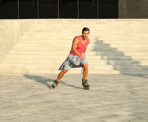 Handsome young man roller skating on city street