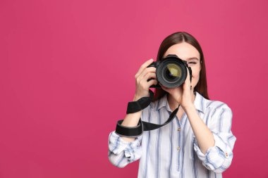 Profesyonel fotoğrafçı pembe arka planda fotoğraf çekiyor