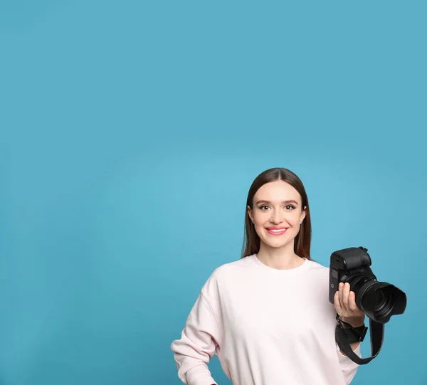 Fotógrafo profissional com câmera moderna em fundo azul claro. Espaço para texto — Fotografia de Stock