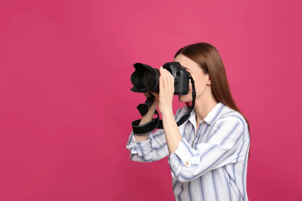 Fotógrafo profissional tirando fotos em fundo rosa — Fotografia de Stock